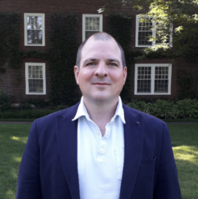 Associate Research Professor, Timothy DeStefano. Wearing a navy suit jacket with a white dress shirt.
